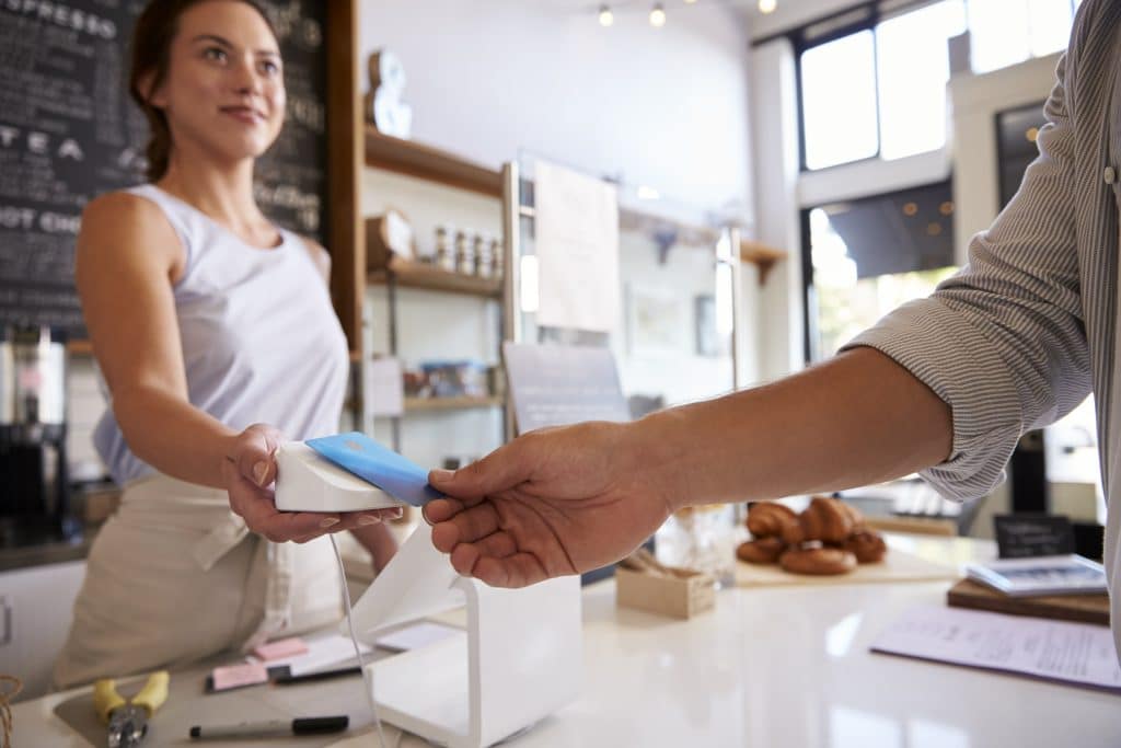 What is surcharge? Person using a debit card for a purchase. 